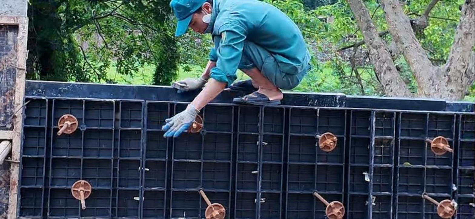 Công nhân lắp côn ty ở đỉnh vách cốp pha nhựa